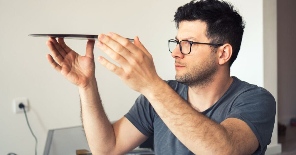 a man looking at the vinyl record